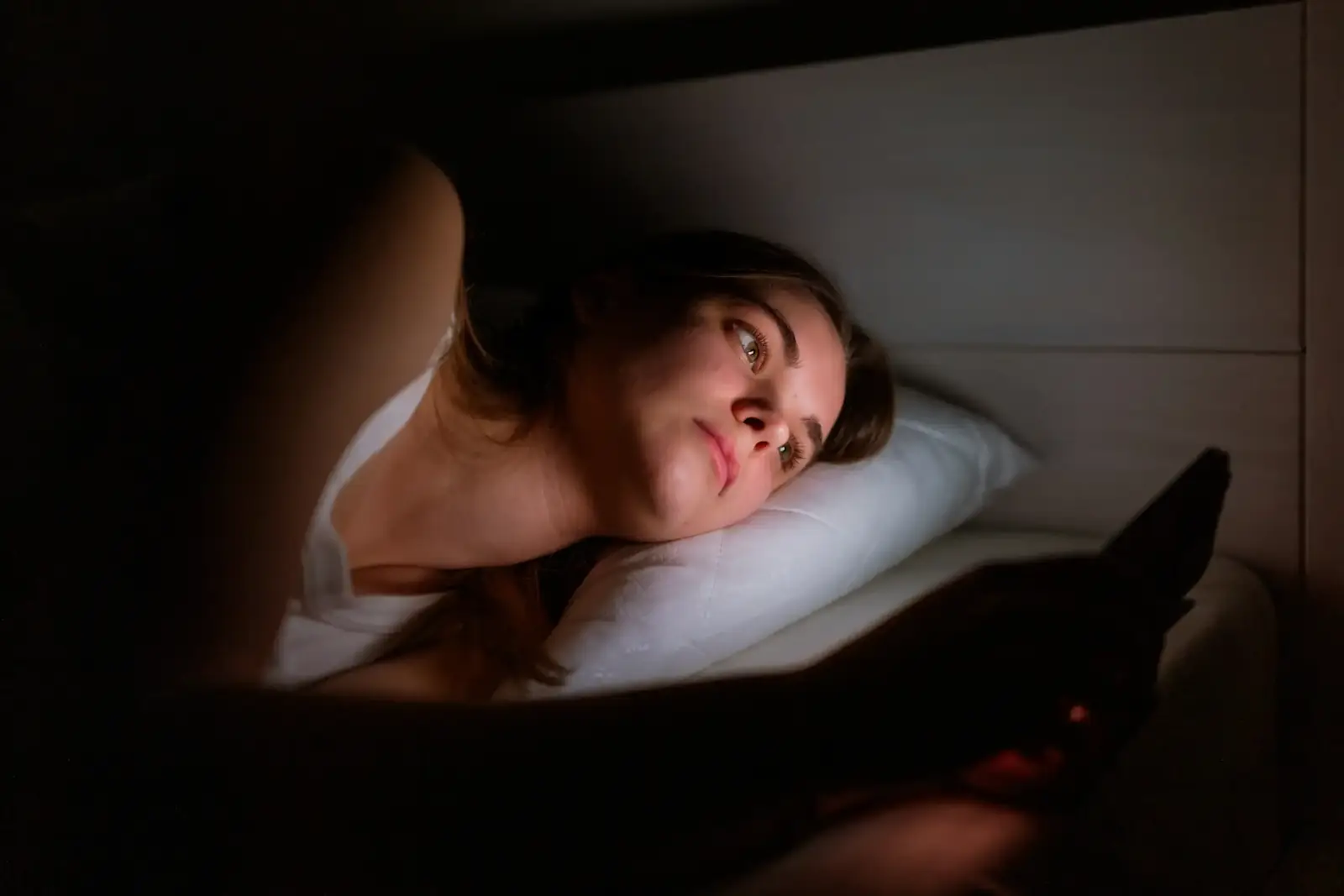 Someone reading on a tablet in bed at night